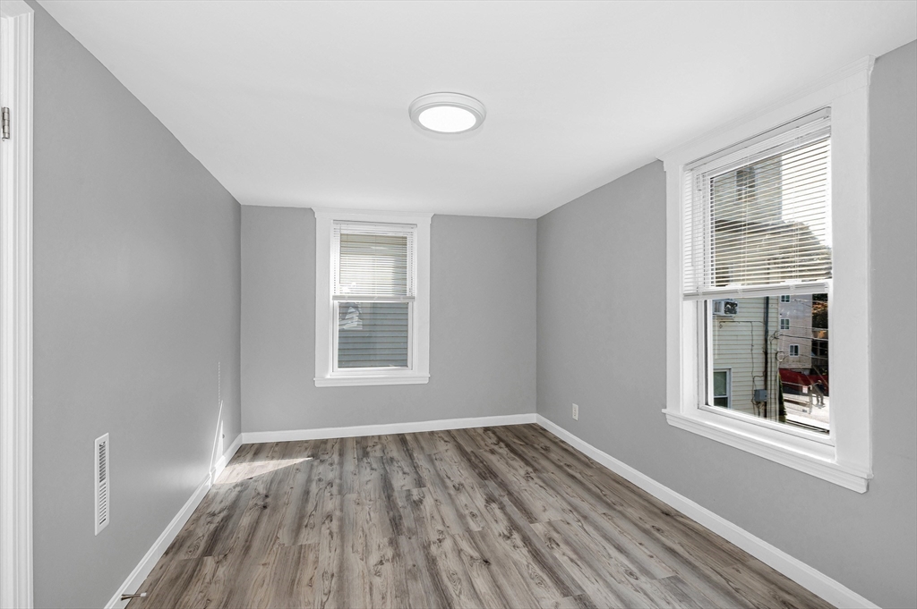 213 Prospect Street Lawrence, MA 01841 - Photo 25 of 33 an empty room with wooden floor and windows