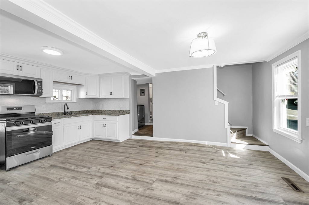 213 Prospect Street Lawrence, MA 01841 - Photo 8 of 33 a large kitchen with cabinets wooden floor and stainless steel appliances