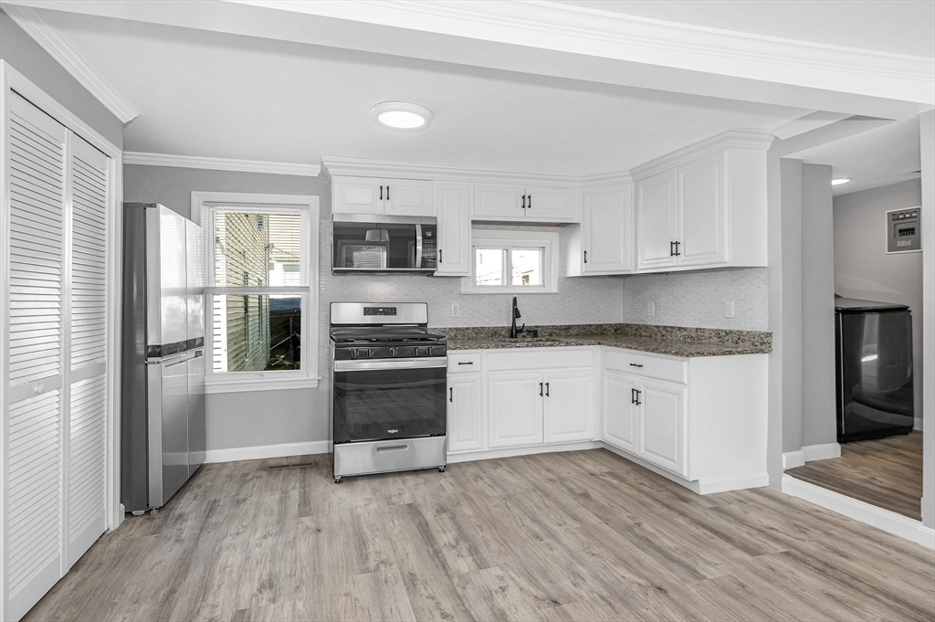 213 Prospect Street Lawrence, MA 01841 - Photo 10 of 33 a kitchen with granite countertop a refrigerator stove top oven and sink