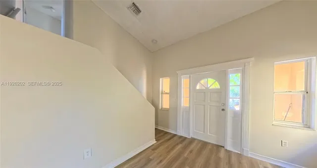 a view of a room with wooden floor and windows
