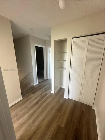 an empty room with wooden floor and closet