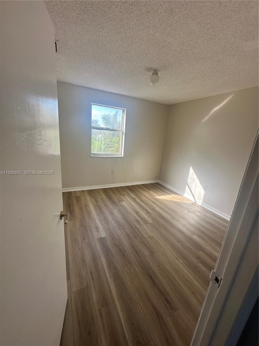 27347 Southwest 117th Place Homestead, FL 33032 - Photo 30 of 37 wooden floor in an empty room with a window