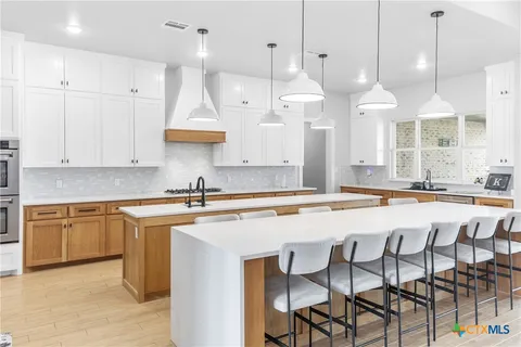 a kitchen with stainless steel appliances granite countertop a sink a stove and a refrigerator