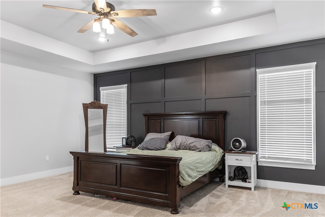 13428 Knob Hill Road Rogers, TX 76569 - Photo 20 of 41 a bedroom with a bed and a chandelier