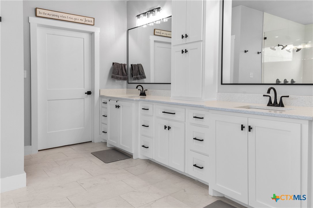 13428 Knob Hill Road Rogers, TX 76569 - Photo 21 of 41 a bathroom with a double vanity sink and mirror