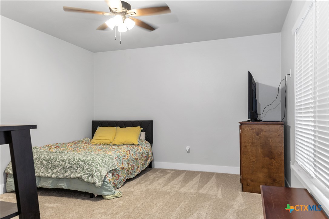13428 Knob Hill Road Rogers, TX 76569 - Photo 28 of 41 a bedroom with a bed and a chandelier