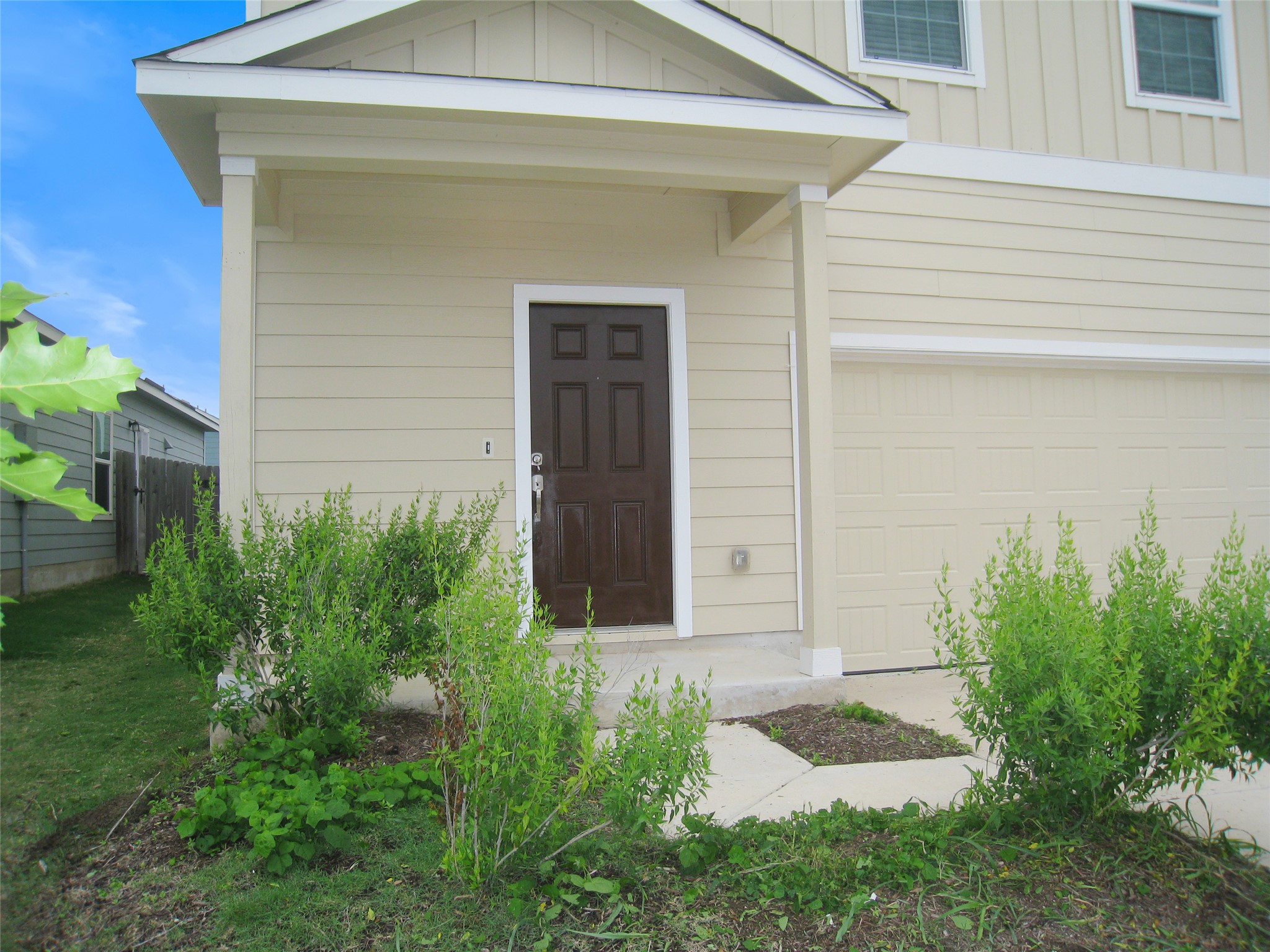 229 Geode Glen Maxwell, TX 78656 - Photo 3 of 19 A welcoming front entry with a warm brown door and an attached garage awaits.