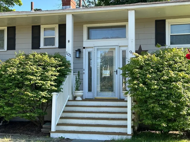 a front view of a house with potted plants