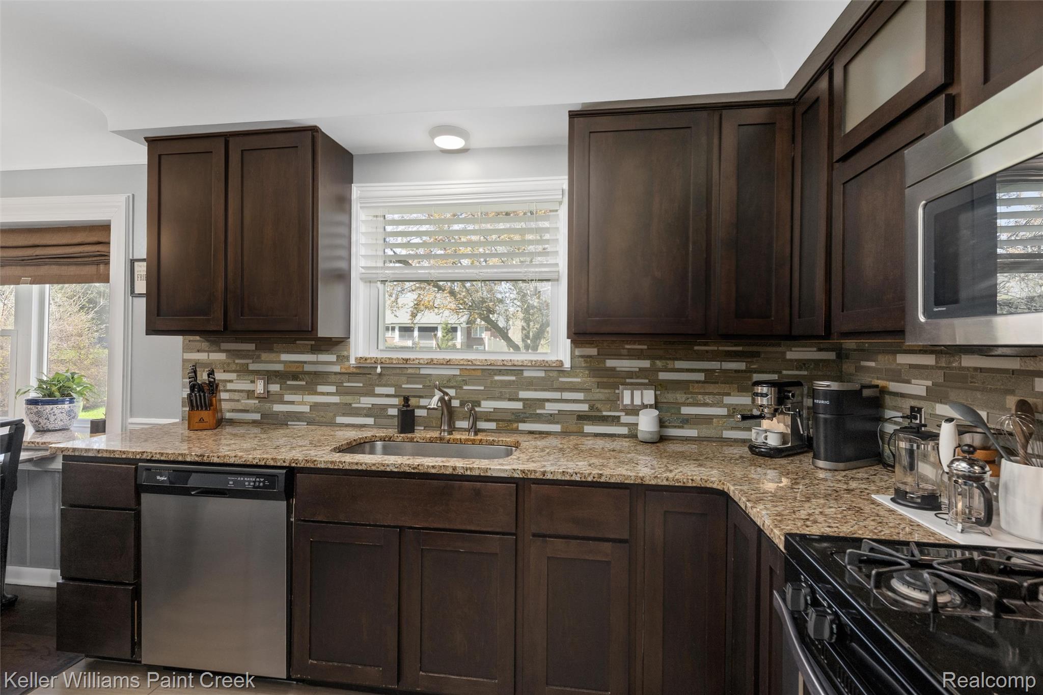 310 Elmhill Road Rochester, MI 48306 - Photo 8 of 37 Kitchen with dark wood finish cabinetry, stainless steel appliances, light stone counters, and tasteful backsplash