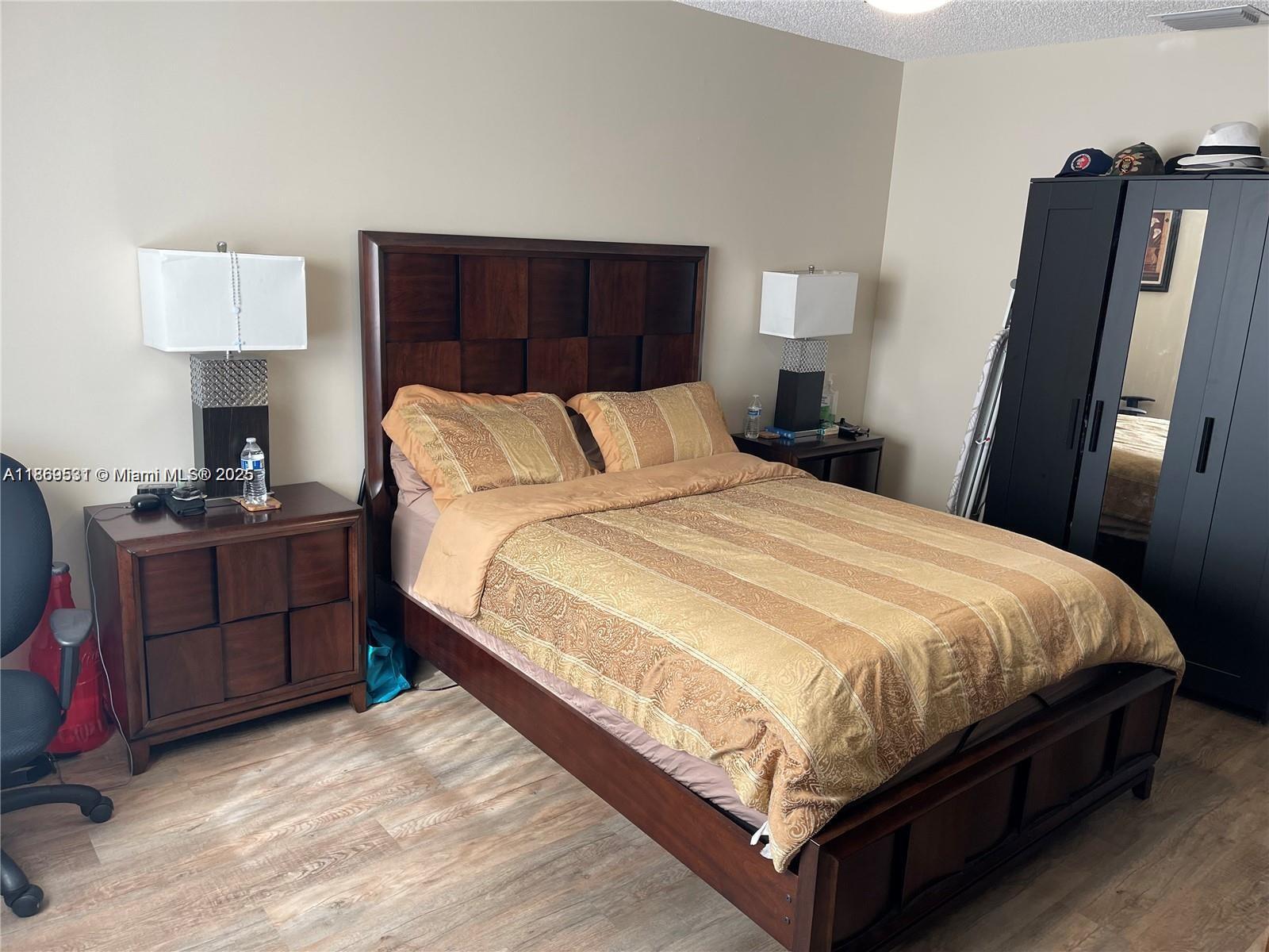 5133 Brisata Circle, Unit L Boynton Beach, FL 33437 - Photo 18 of 42 a large bed sitting in a bedroom next to a lamp on dresser and a lamp