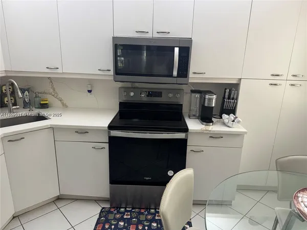 a large bed sitting in a bedroom next to a lamp on dresser and a lamp