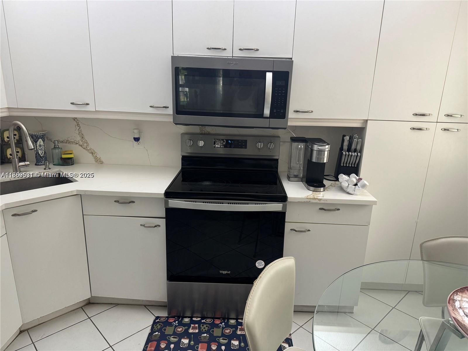 5133 Brisata Circle, Unit L Boynton Beach, FL 33437 - Photo 10 of 42 a kitchen with a sink stove and cabinets