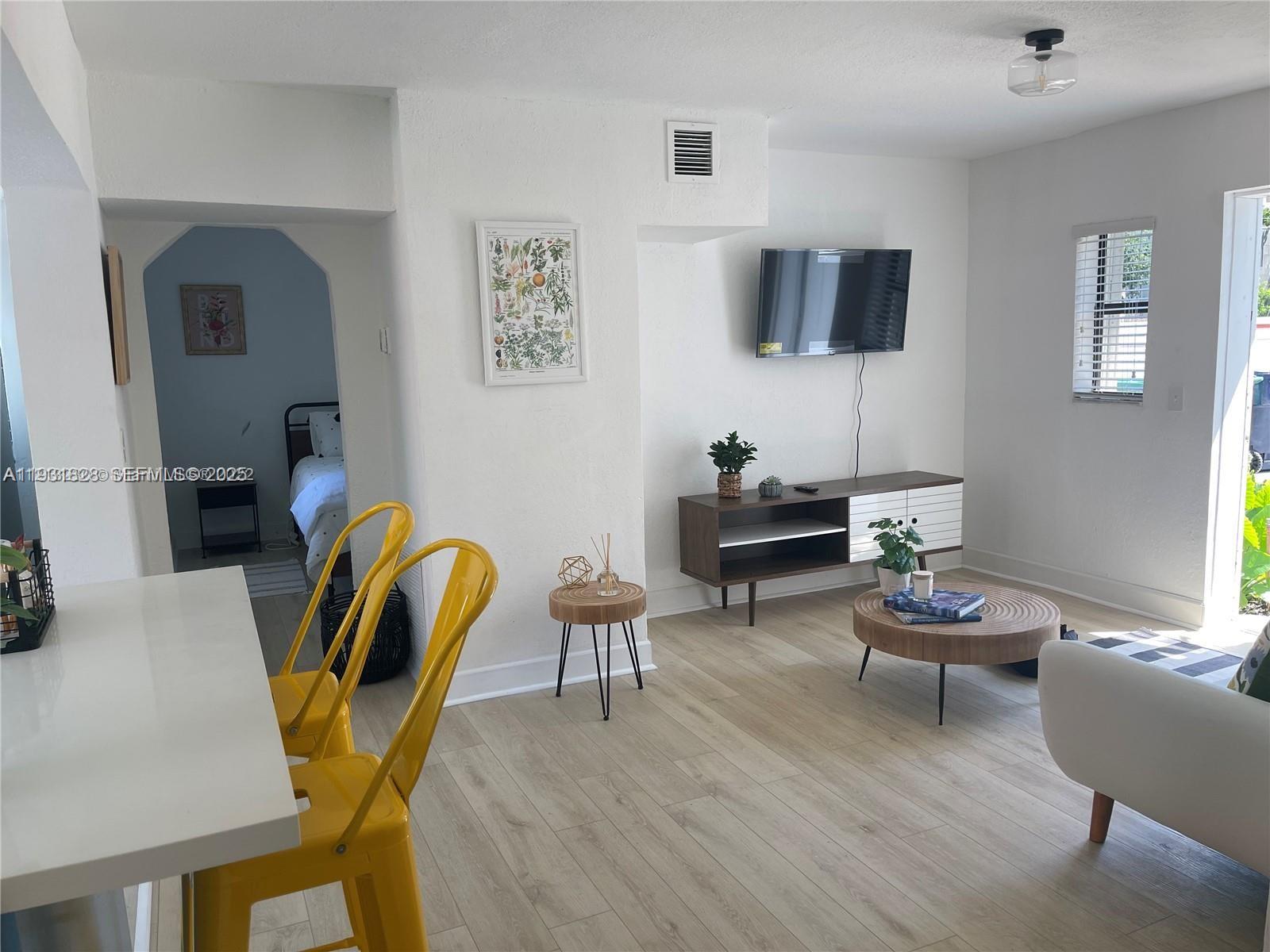 1560 Northeast 145th Street, Unit 1 Miami, FL 33161 - Photo 6 of 11 a living room with furniture and wooden floor