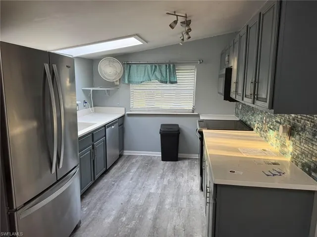 a kitchen with stainless steel appliances granite countertop a sink a stove and refrigerator