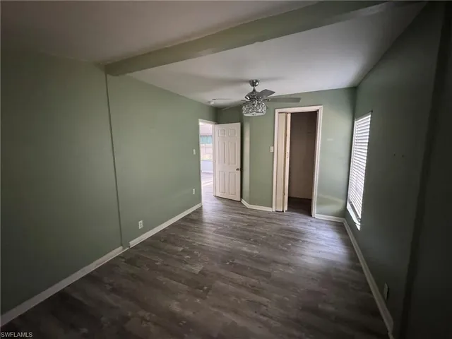an empty room with closet and chandelier fan