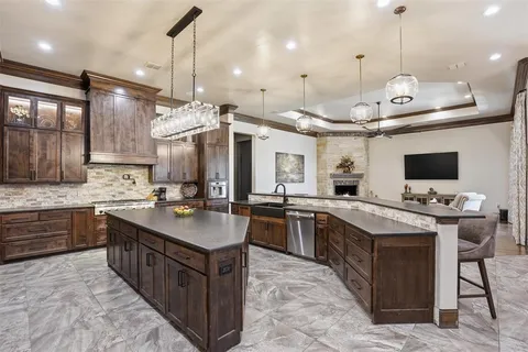 a kitchen with granite countertop a sink appliances and cabinets