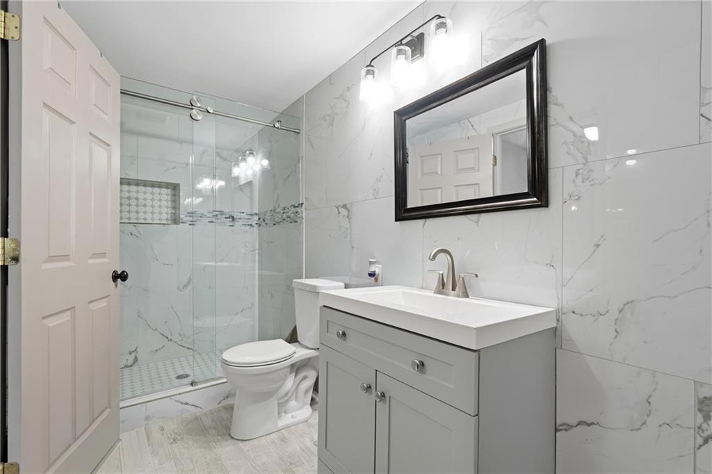 1295 Double Bridges Road Winder, GA 30680 - Photo 15 of 57 a bathroom with a toilet sink and mirror