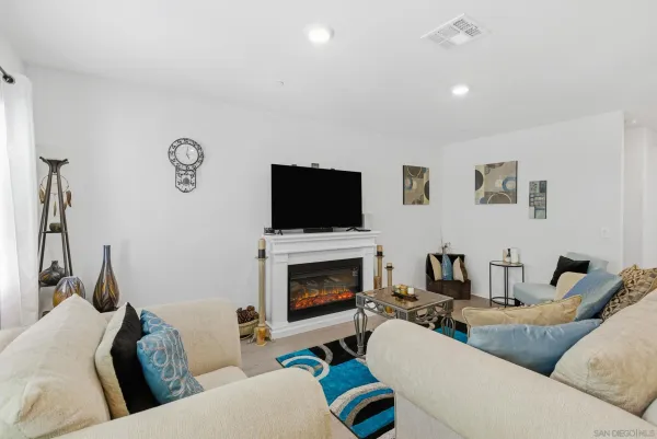 a living room with furniture a flat screen tv and a fireplace