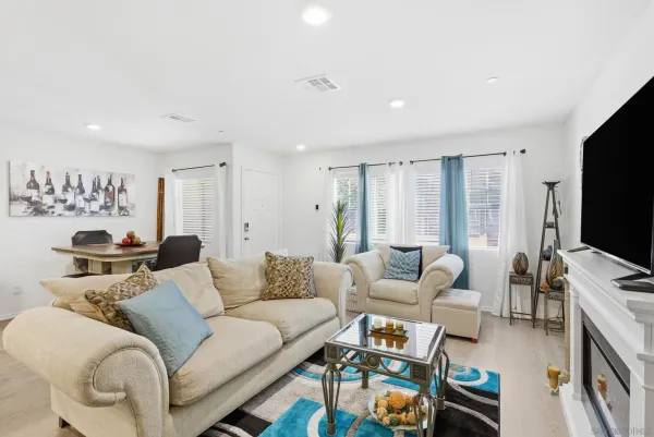 a living room with furniture a flat screen tv and a large window