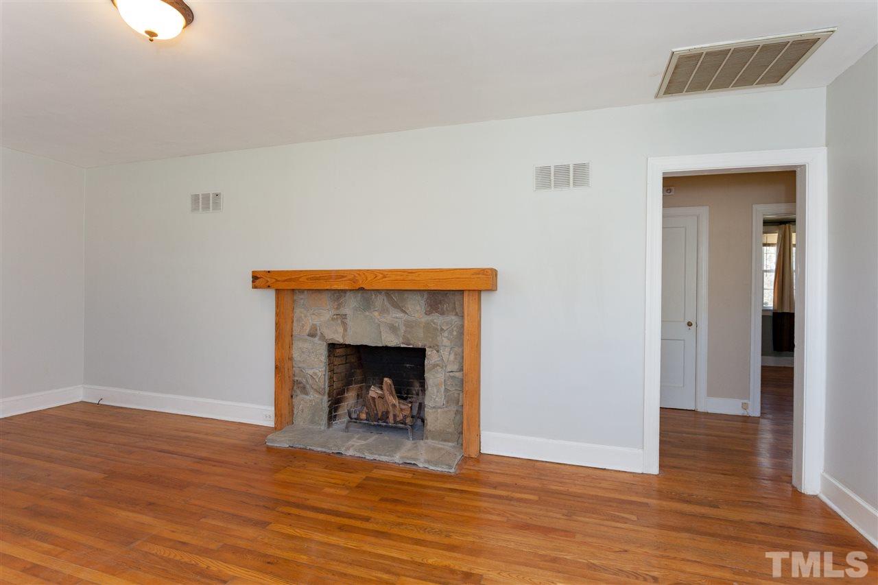 10819 North Roxboro Street Rougemont, NC 27572 - Photo 3 of 25 a view of an empty room with wooden floor and a fireplace