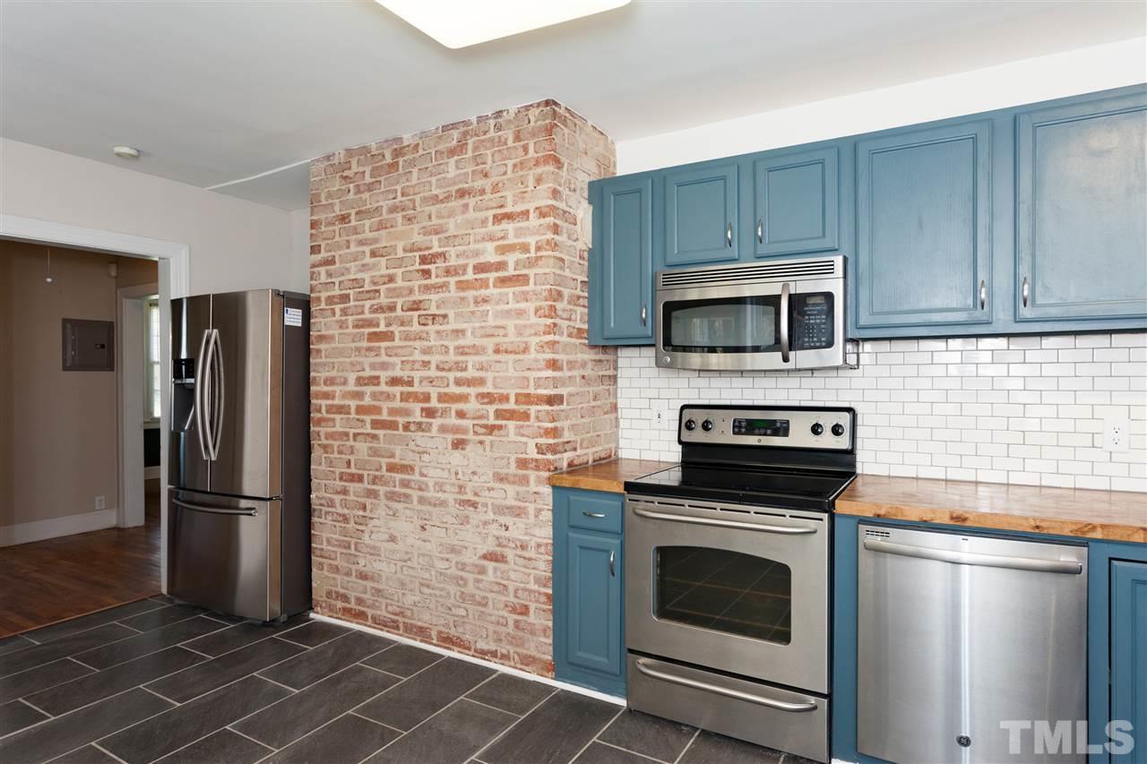 10819 North Roxboro Street Rougemont, NC 27572 - Photo 22 of 25 a kitchen with granite countertop a stove microwave and refrigerator