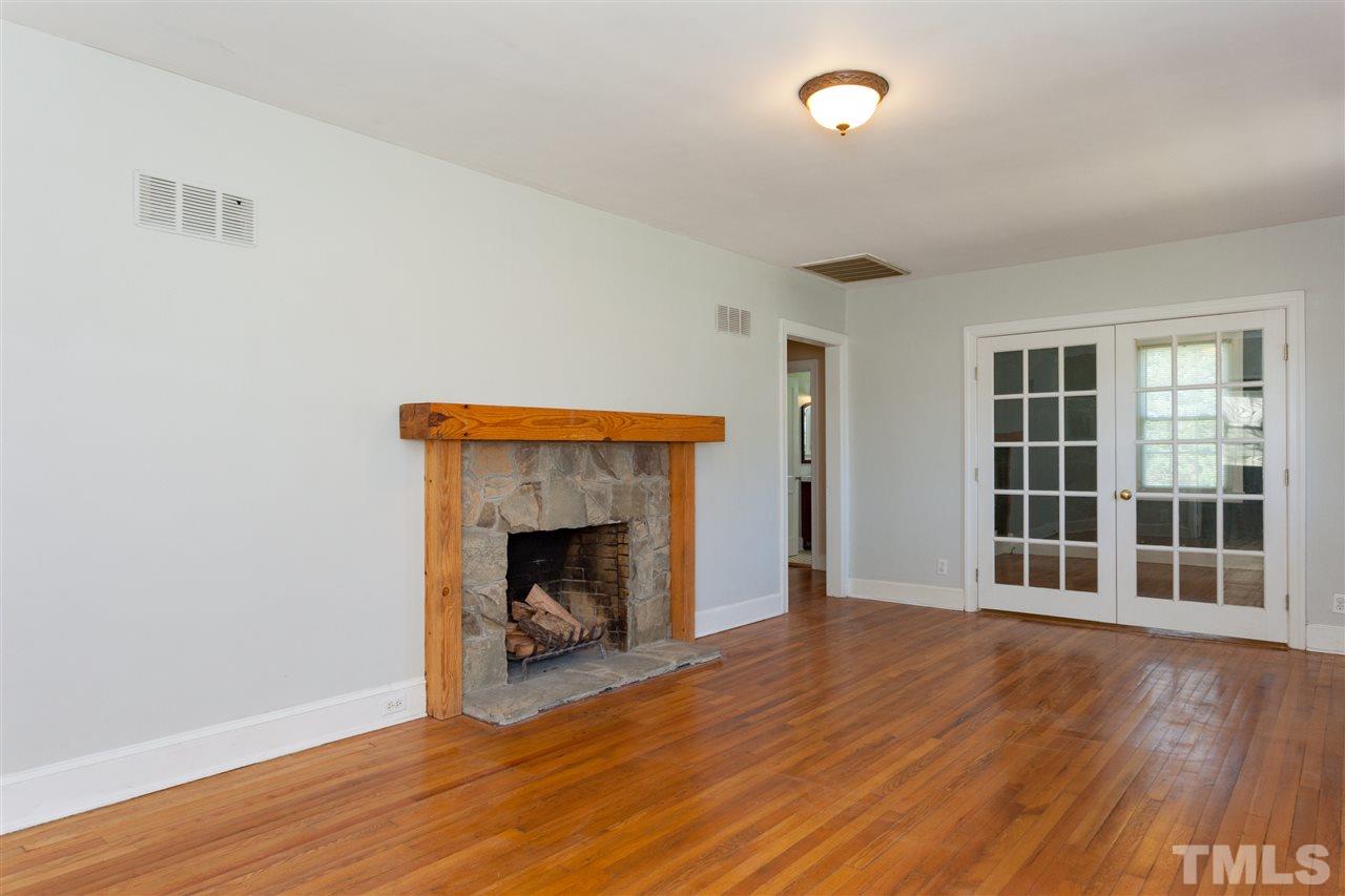 10819 North Roxboro Street Rougemont, NC 27572 - Photo 4 of 25 a view of an empty room with wooden floor and a fireplace