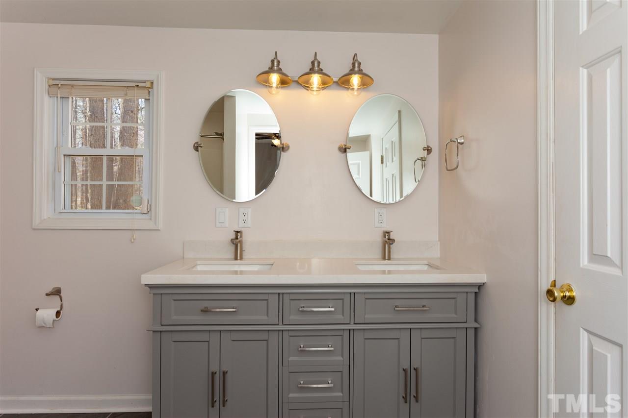 10819 North Roxboro Street Rougemont, NC 27572 - Photo 8 of 25 a bathroom with a double vanity sink and mirror