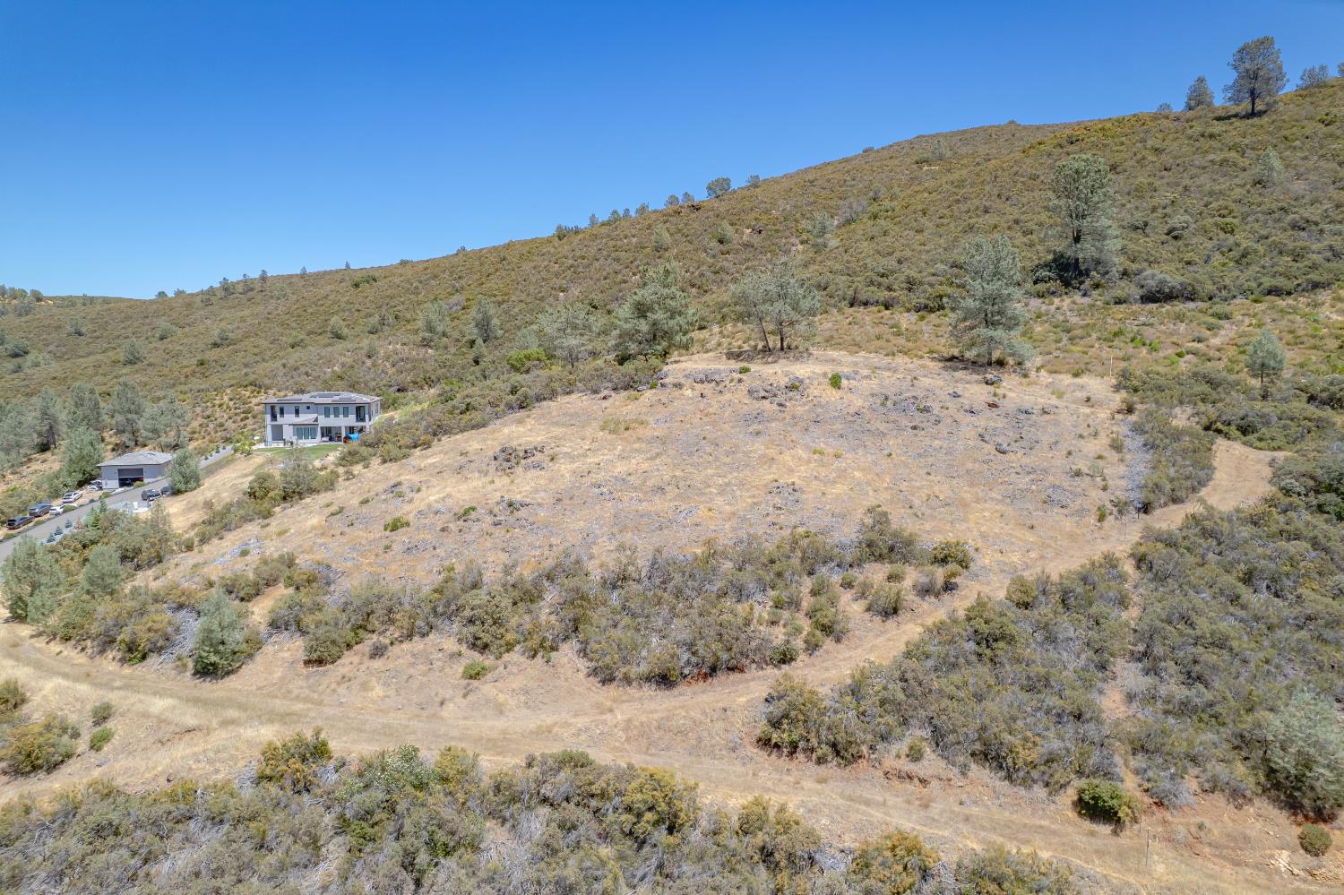 417 Salmon Falls Road El Dorado Hills, CA 95762 - Photo 4 of 47 a view of a dry yard with mountains in the background