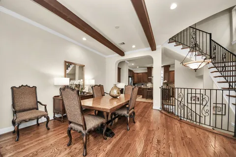 a dining room with furniture entryway and wooden floor