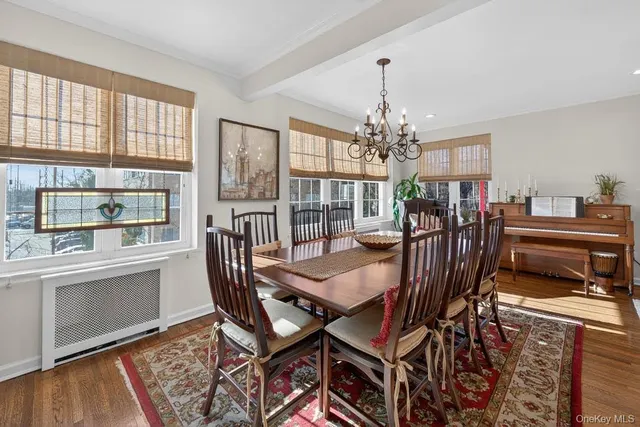 a view of a dining room with furniture a chandelier and wooden floor