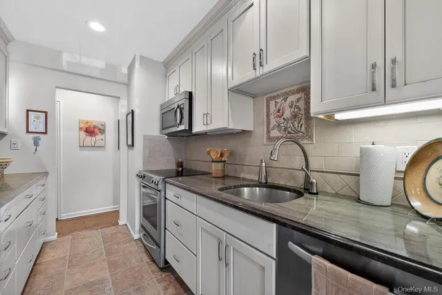 a kitchen with stainless steel appliances granite countertop a sink stove and cabinets