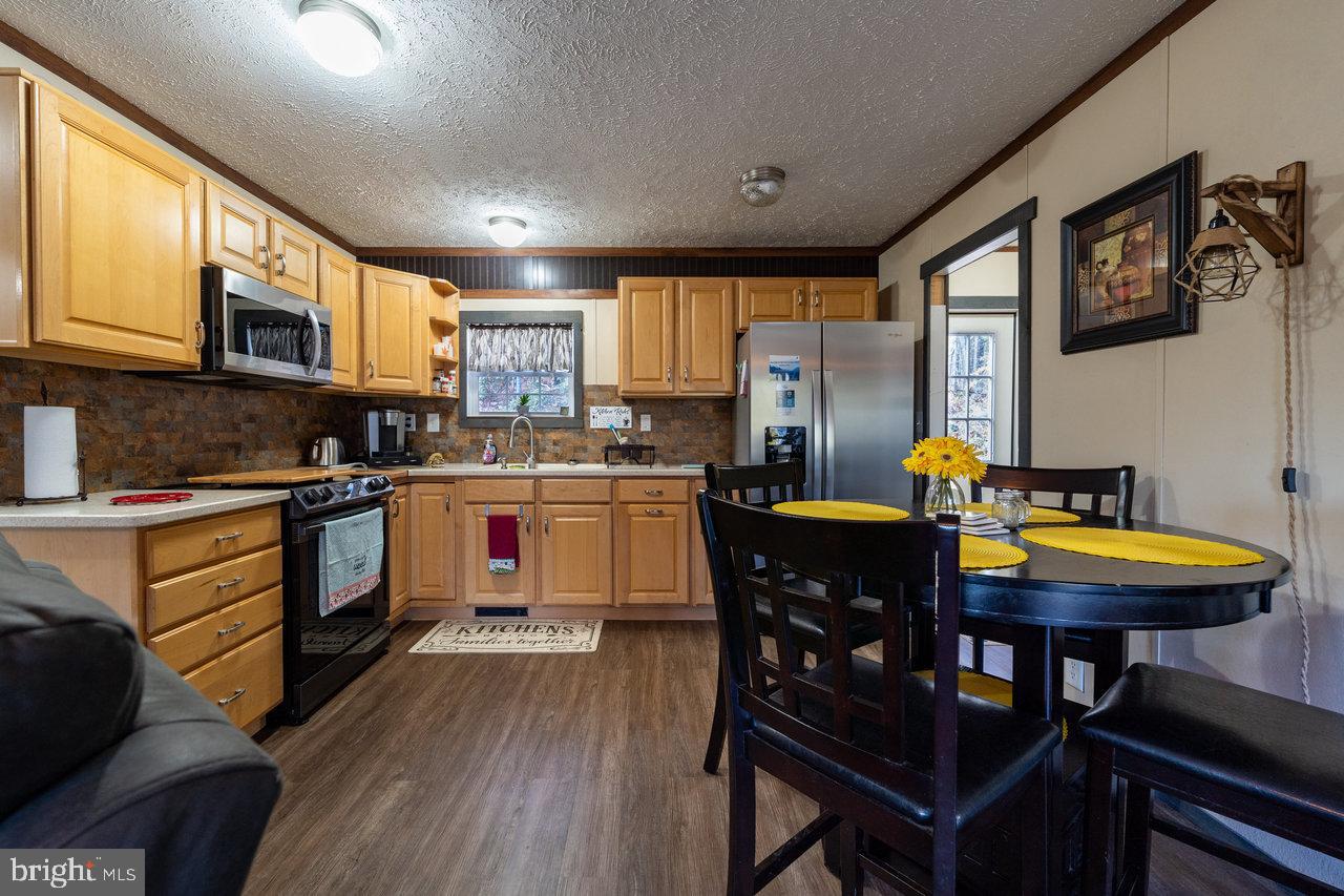 187 Holly Hl Road Luray, VA 22835 - Photo 30 of 60 a kitchen with stainless steel appliances granite countertop a stove a sink dishwasher a microwave oven with a dining table and chairs