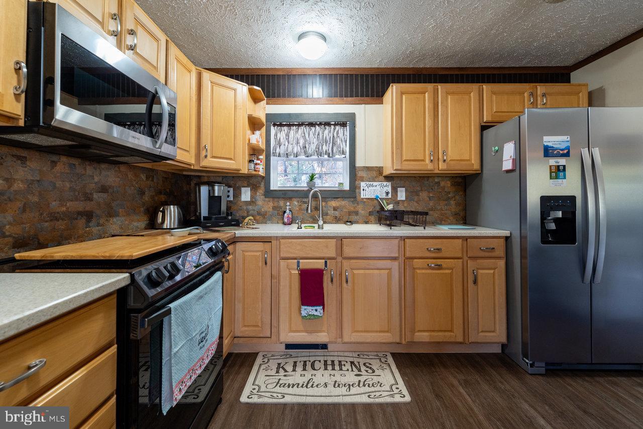 187 Holly Hl Road Luray, VA 22835 - Photo 31 of 60 a kitchen with stainless steel appliances granite countertop a stove a sink dishwasher and a microwave oven with cabinets