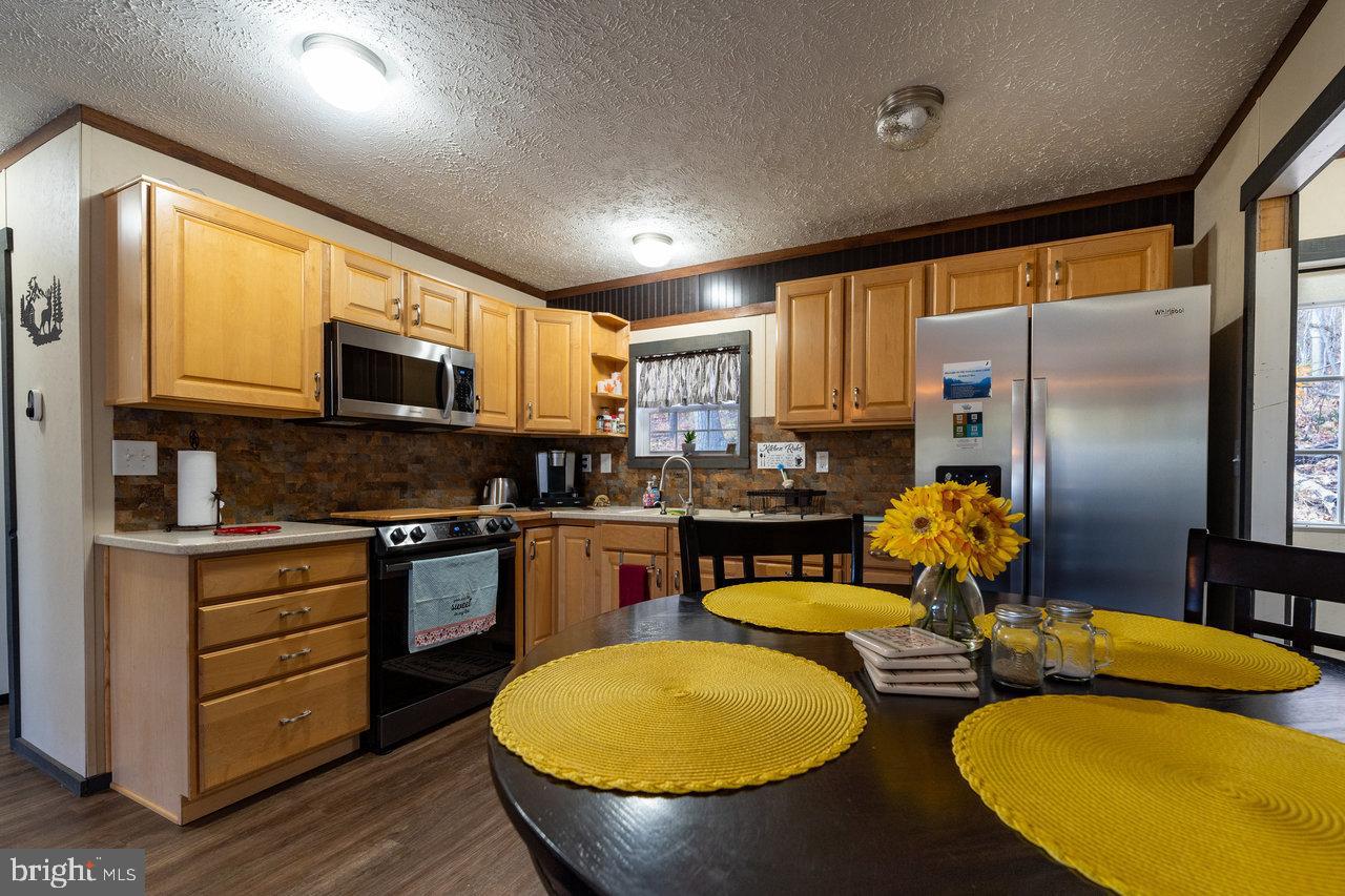 187 Holly Hl Road Luray, VA 22835 - Photo 32 of 60 a kitchen with sink refrigerator dining table and chairs