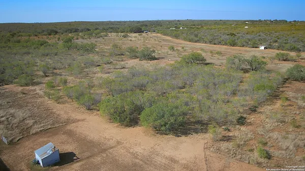 an aerial view of a house with a yard and ocean view