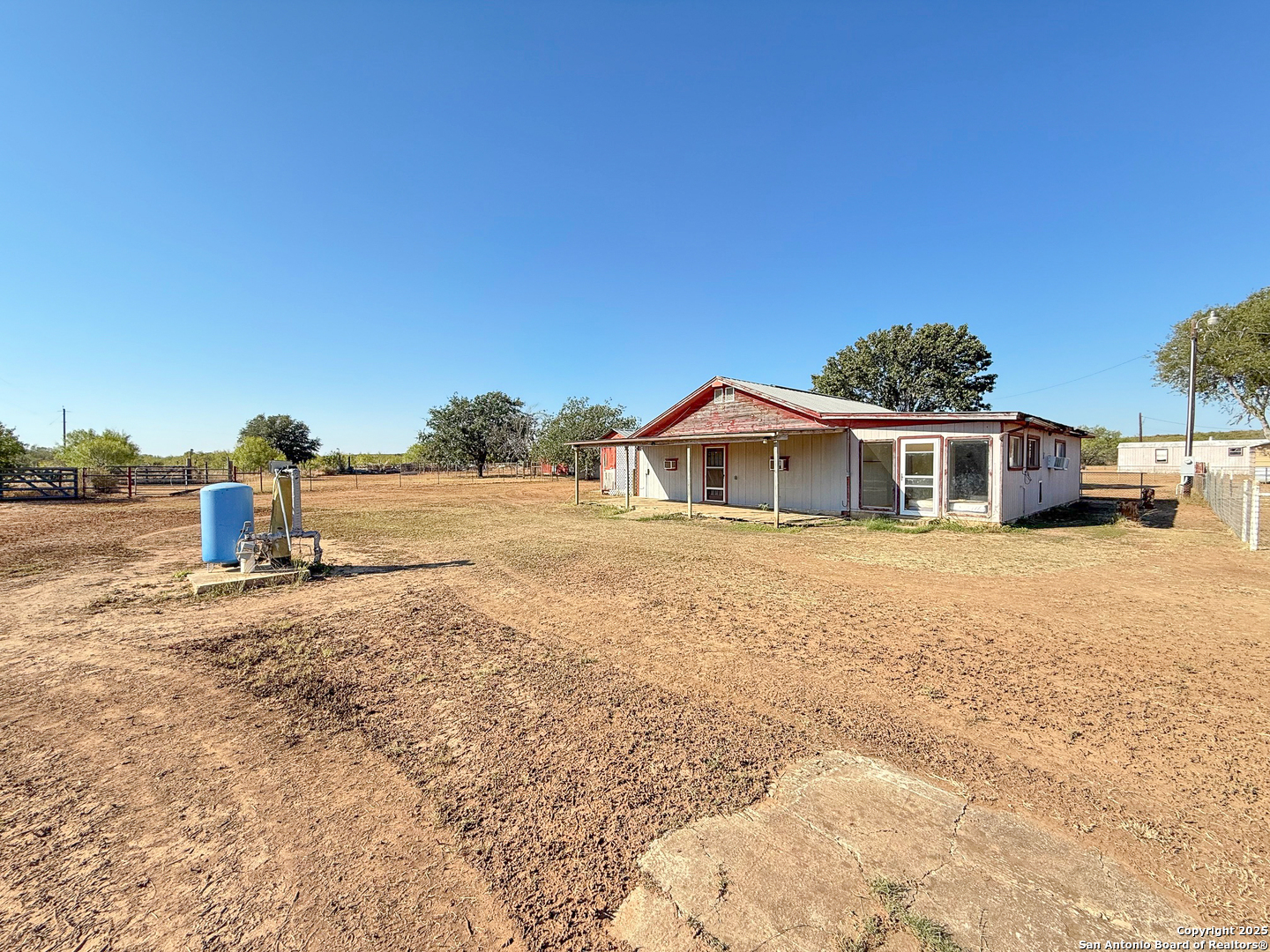 179 Private Road 6624 Devine, TX 78016 - Photo 3 of 20 a front view of a house with a yard