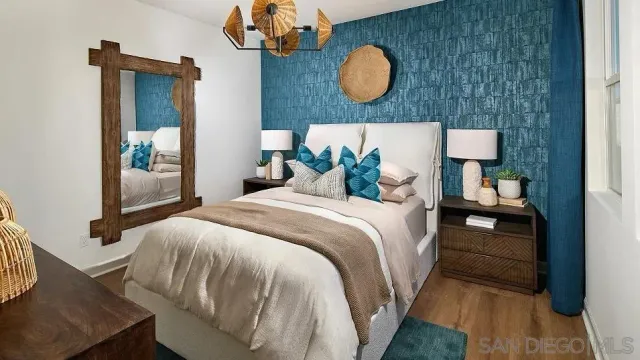 a bedroom with a large bed and wooden floor