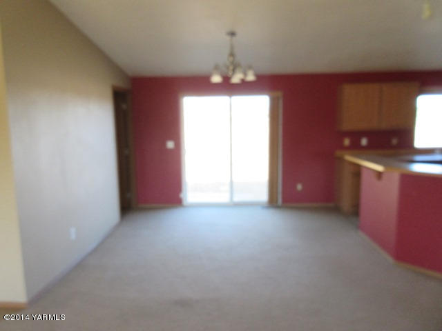 565 Sheep Company Road Selah, WA 98942 - Photo 13 of 30 an empty room with windows and chandelier