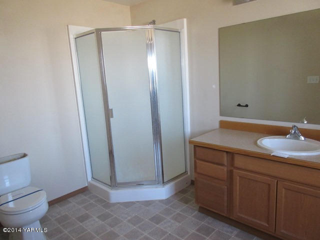 565 Sheep Company Road Selah, WA 98942 - Photo 7 of 30 a bathroom with a granite countertop sink a toilet and a mirror
