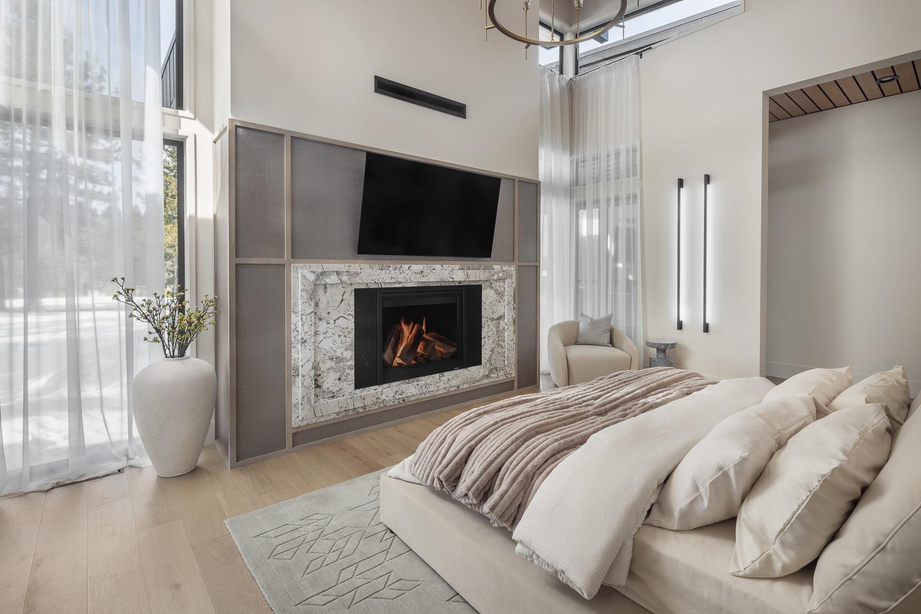 11633 Henness Road Truckee, CA 96161 - Photo 17 of 26 a bedroom with a bed and a fireplace