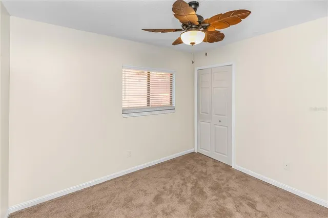 an empty room with a window and a ceiling fan