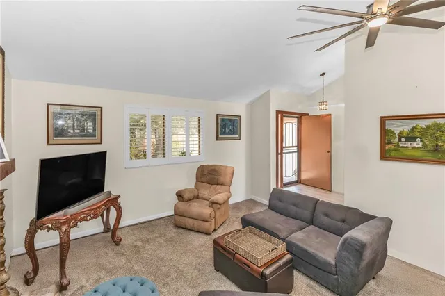 a living room with furniture a flat screen tv and a window