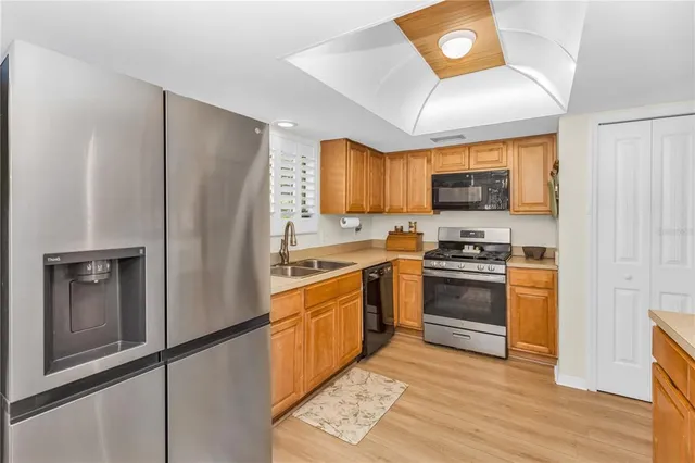 a kitchen with stainless steel appliances granite countertop a refrigerator stove and sink