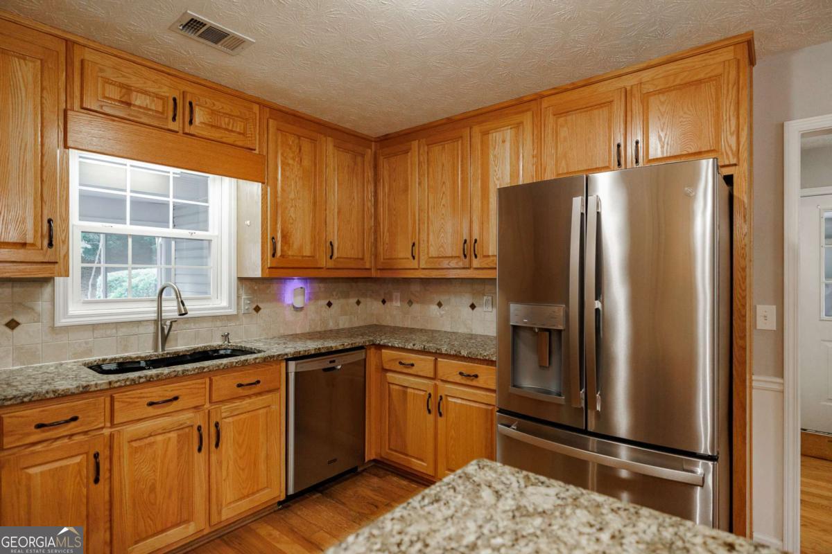 2249 Cluster Lane Grayson, GA 30017 - Photo 16 of 53 a kitchen with stainless steel appliances granite countertop a refrigerator sink and cabinets