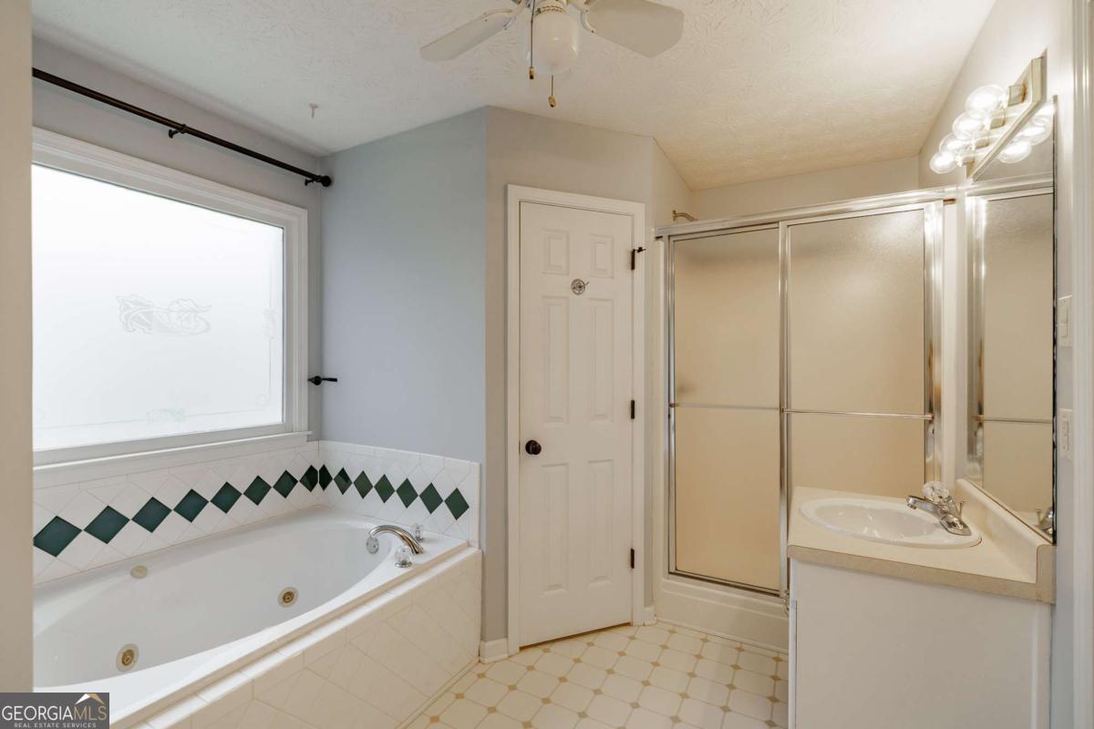 2249 Cluster Lane Grayson, GA 30017 - Photo 19 of 53 a bathroom with a bathtub and a shower
