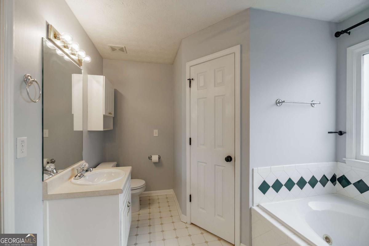 2249 Cluster Lane Grayson, GA 30017 - Photo 21 of 53 a bathroom with a sink a toilet and shower