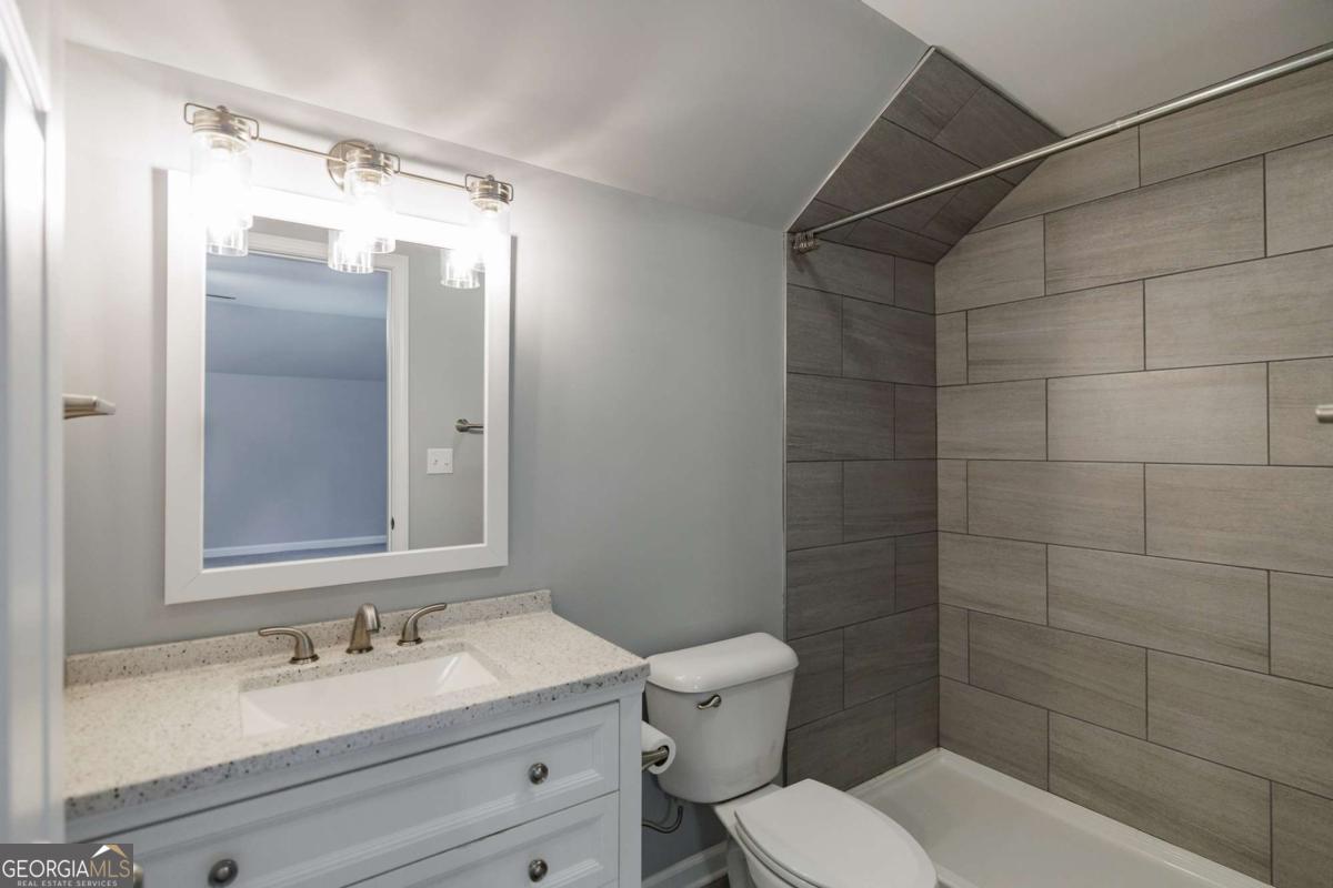 2249 Cluster Lane Grayson, GA 30017 - Photo 32 of 53 a bathroom with a granite countertop sink toilet and shower