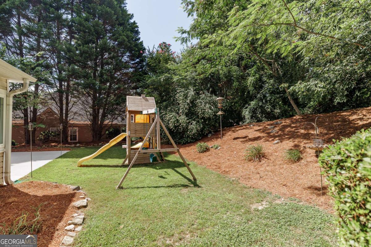 2249 Cluster Lane Grayson, GA 30017 - Photo 38 of 53 a view of a backyard with a slide and a tree