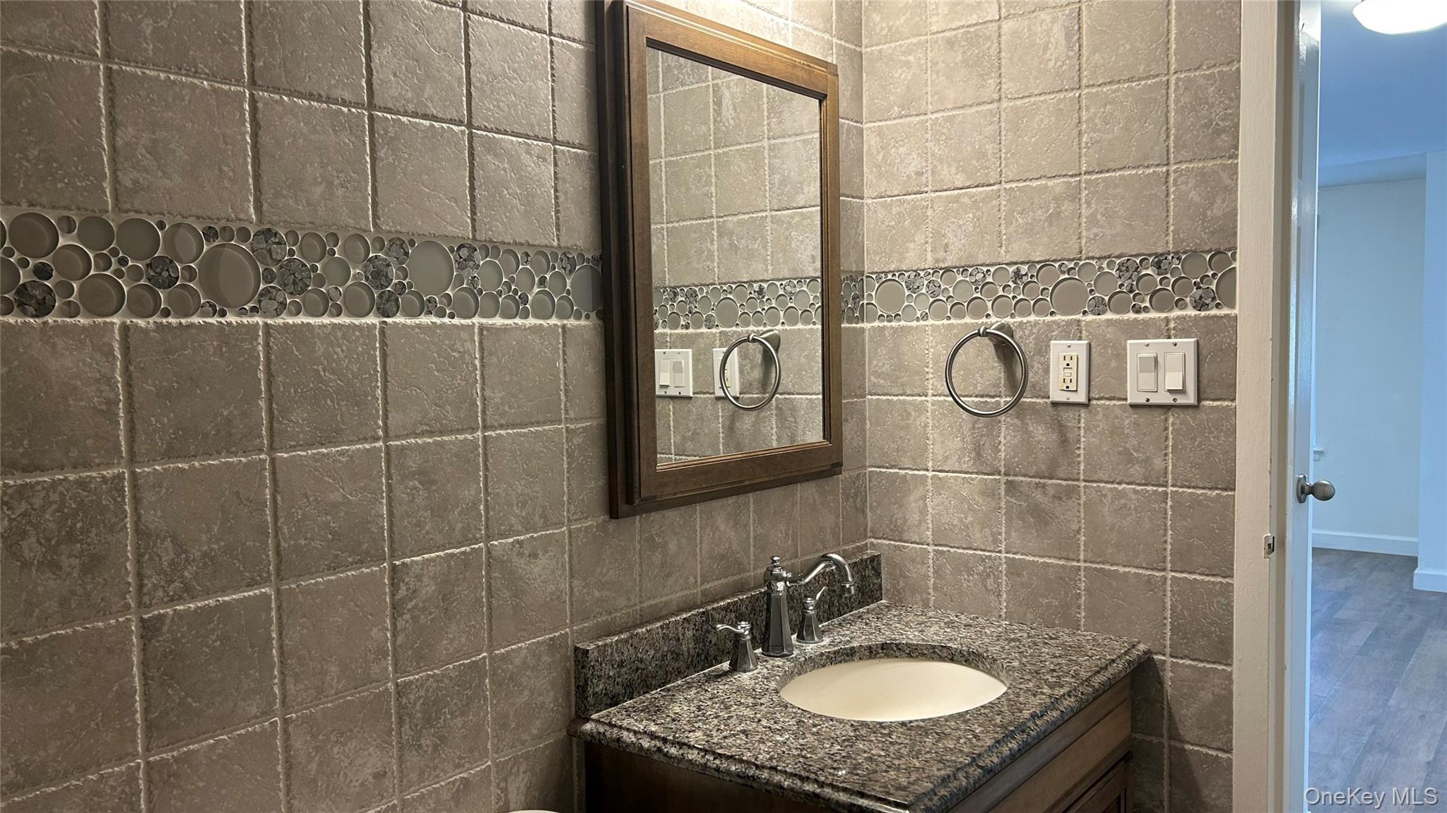 103 Birchwood Road, Unit 103 Medford, NY 11763 - Photo 11 of 13 a bathroom with a granite countertop sink a mirror and a shower