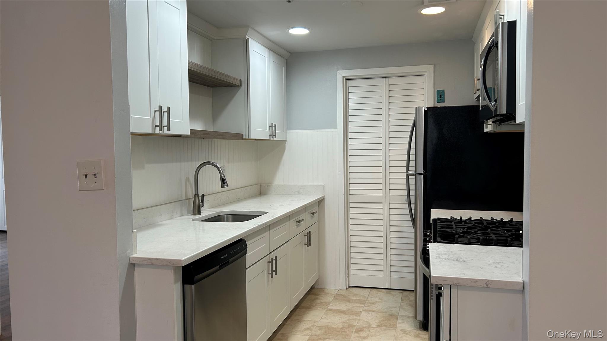 103 Birchwood Road, Unit 103 Medford, NY 11763 - Photo 5 of 13 a kitchen with a sink and a refrigerator